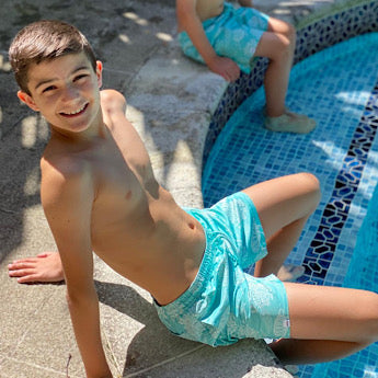 Turquoise turtle print board shorts