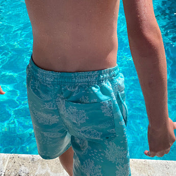 Turquoise turtle print board shorts